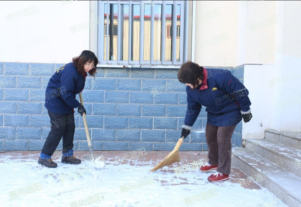 揮舞著鐵鍬和笤帚，相互配合掃雪圖片